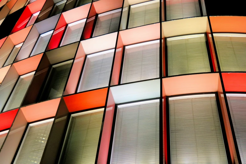 red, orange and gray building next to streetlight at night