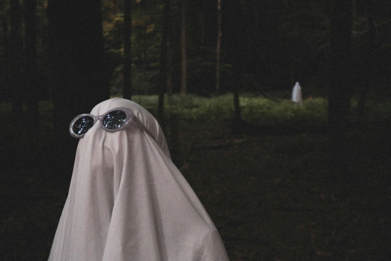 someone wearing a ghost costume with their eyes covered