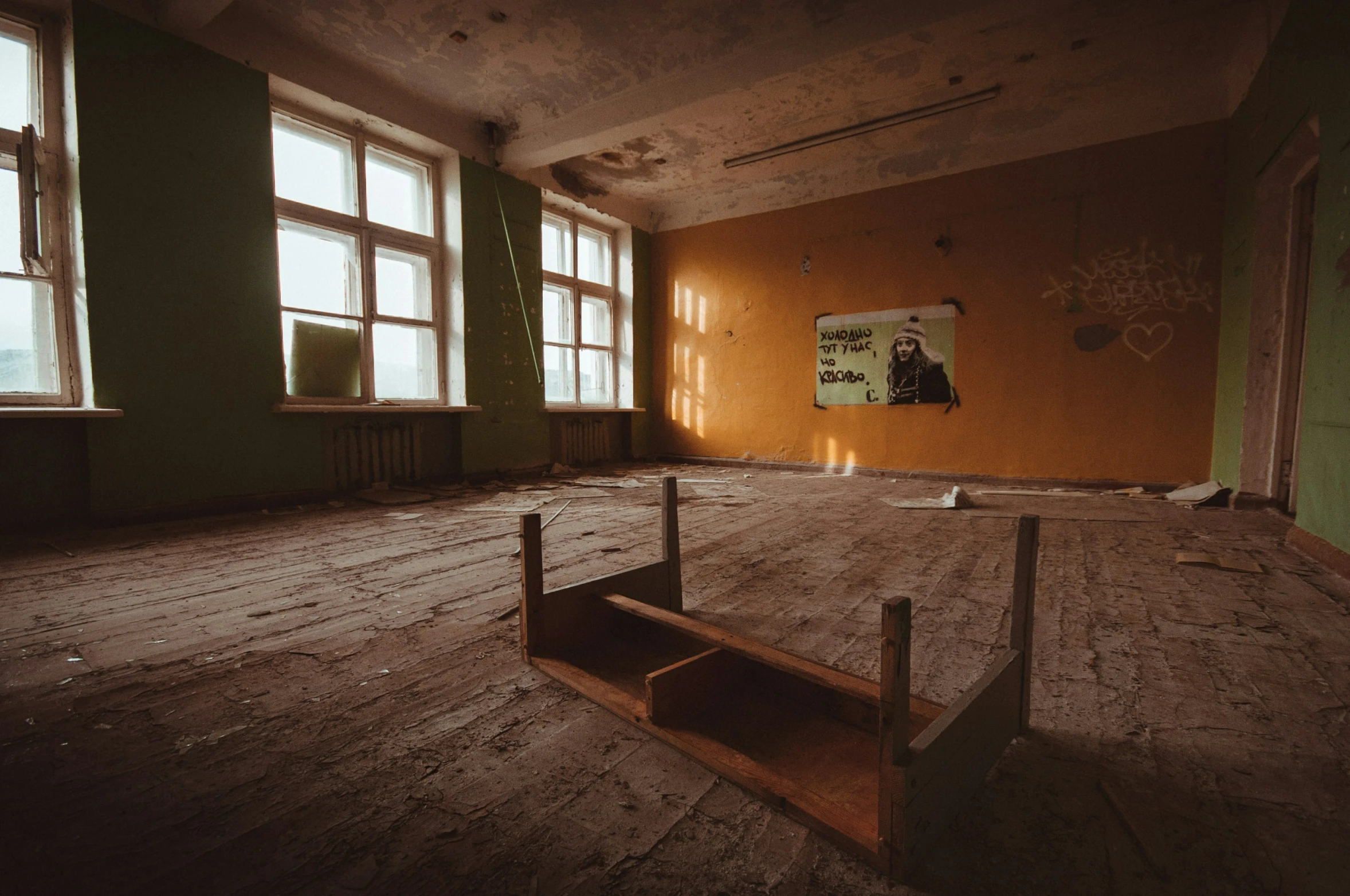 a run down room that has some window frames and a wooden floor