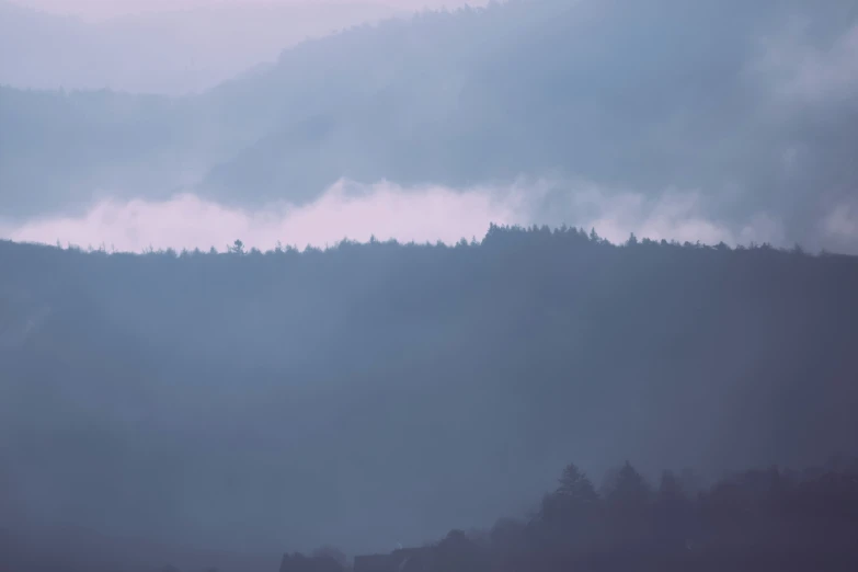 a plane flying low over some mountains in the mist