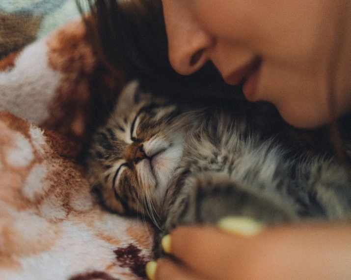 a woman is cuddling a cat on her lap