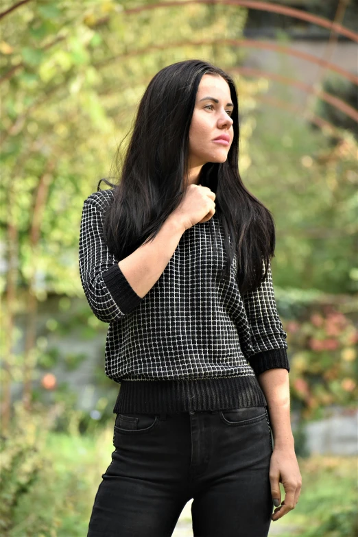 a beautiful young woman standing outside in black pants