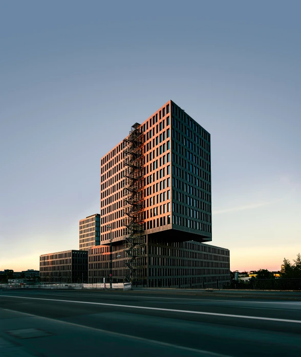 two large buildings sit along the highway in front of a parking lot