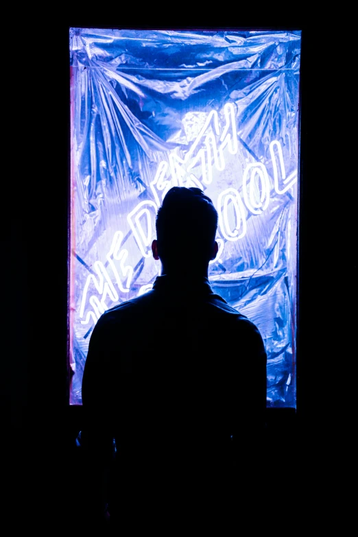 a man standing in front of an advertising sign