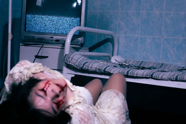 a woman laying down in a hospital room next to a monitor