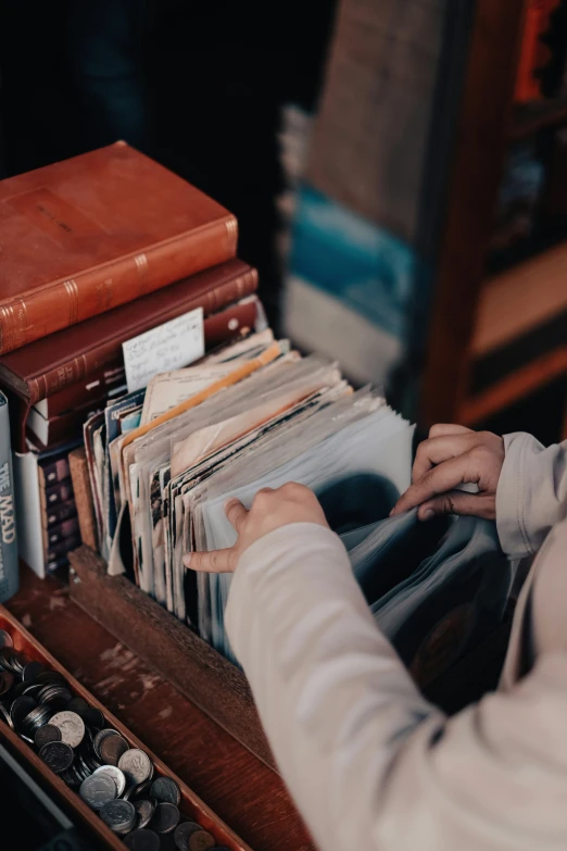 a person picking up a book off of a table