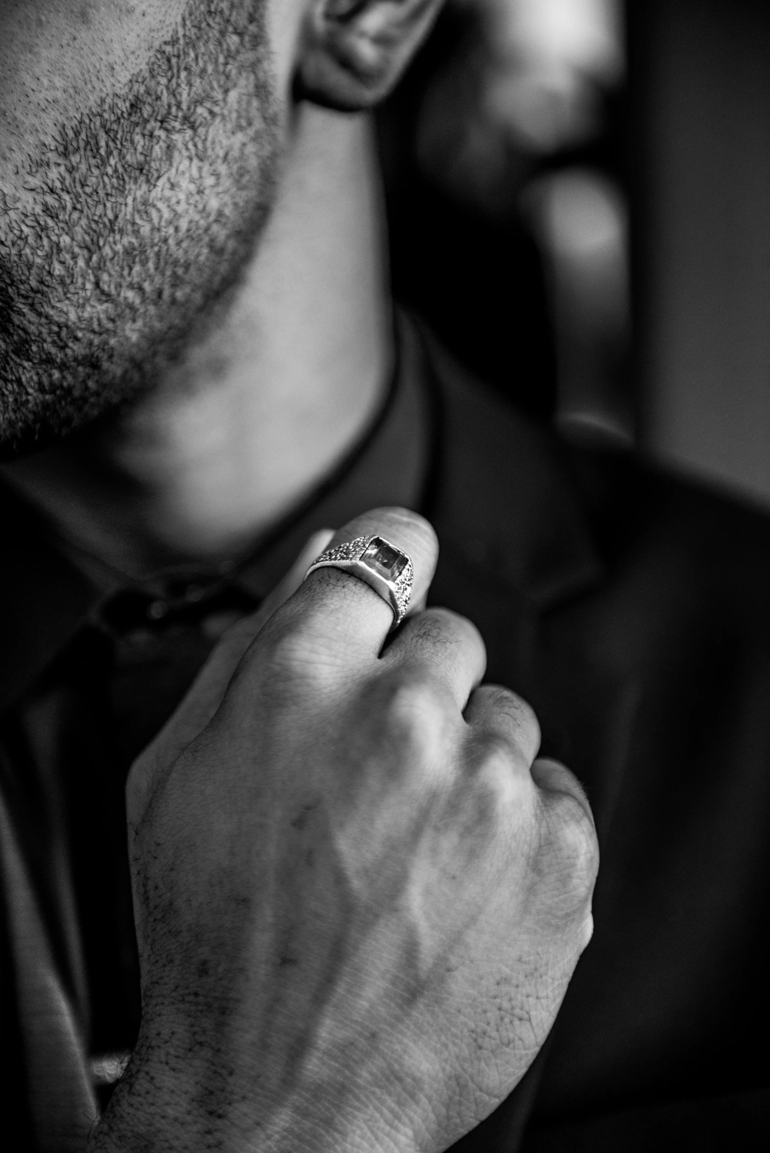 a man in a suit with a ring on his finger