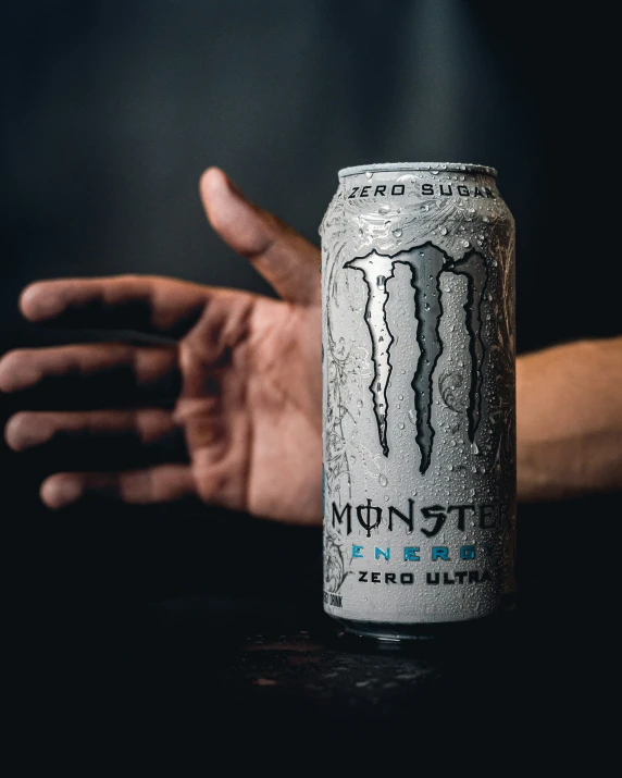 a can of monster energy drink in hand