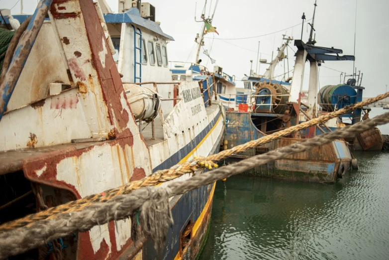 a close up of an old boat docked with ropes