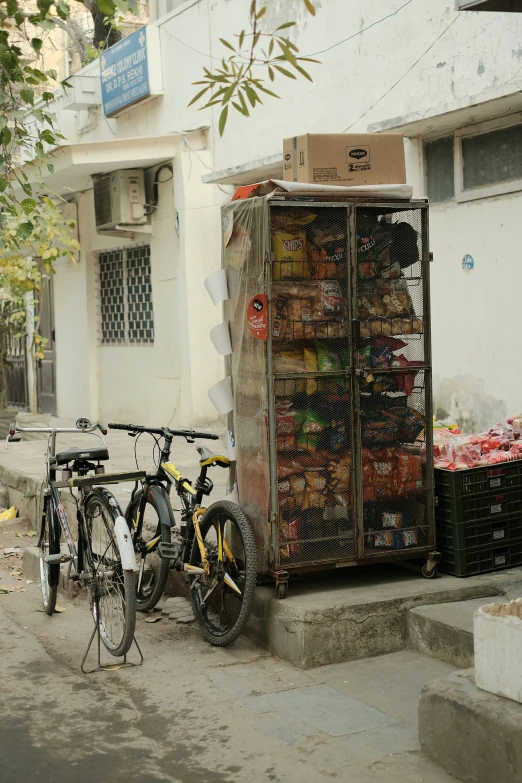 three bicycles are parked next to a fruit and vegetable stand