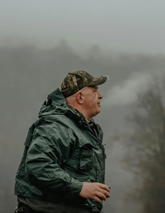 a man standing outside in a rain jacket