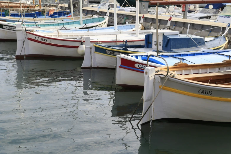 boats are lined up in a harbor with several different sizes