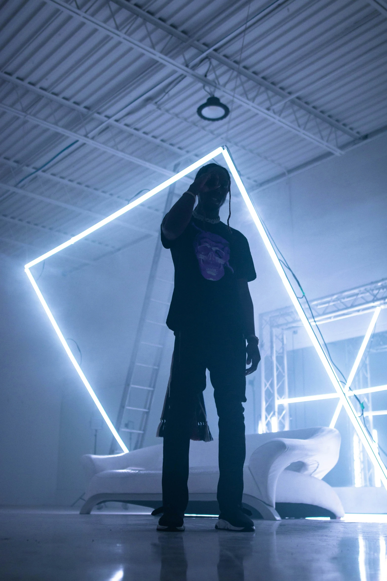 a man is standing in front of an abstract neon wall