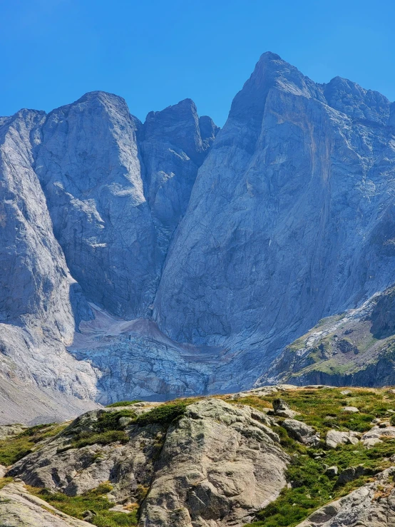 the view of mountains with green vegetation and a few animals in a valley