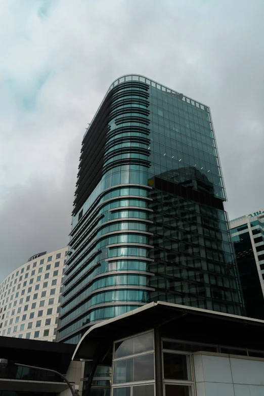 a very tall glass building on a cloudy day