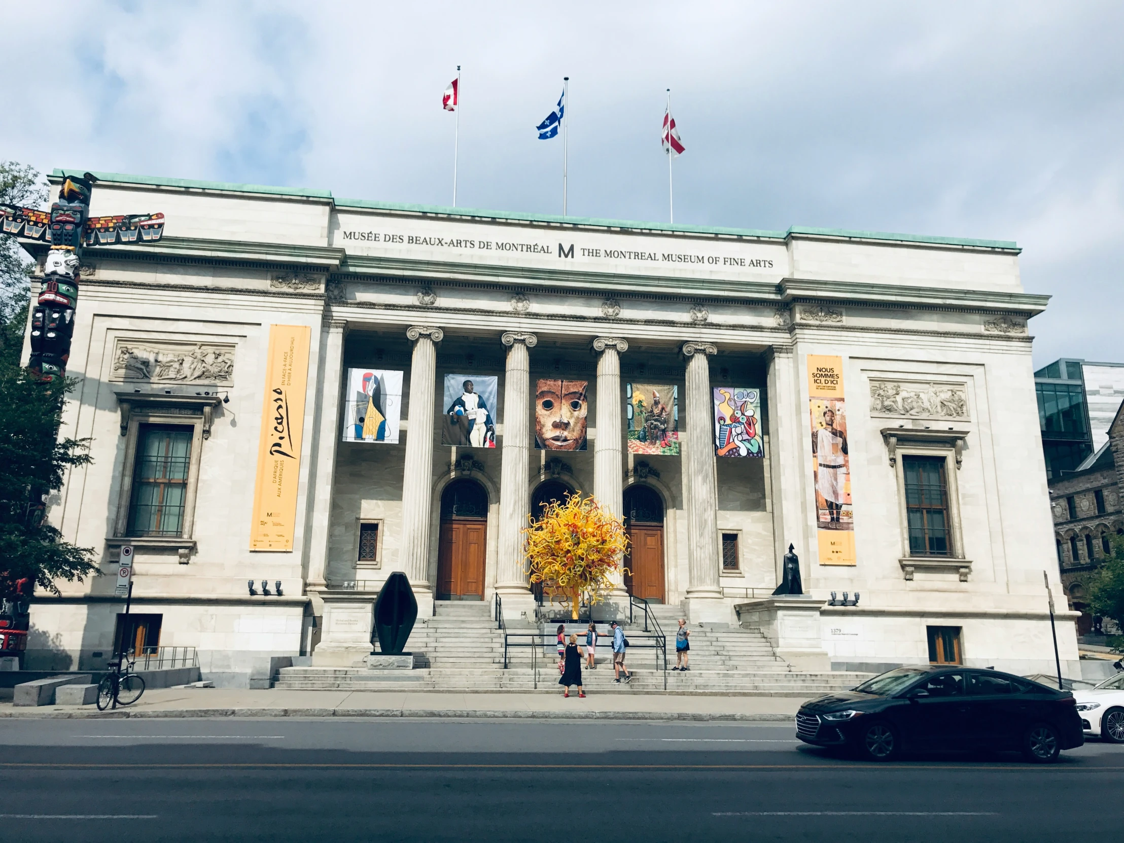 a big building with columns and flags on the roof