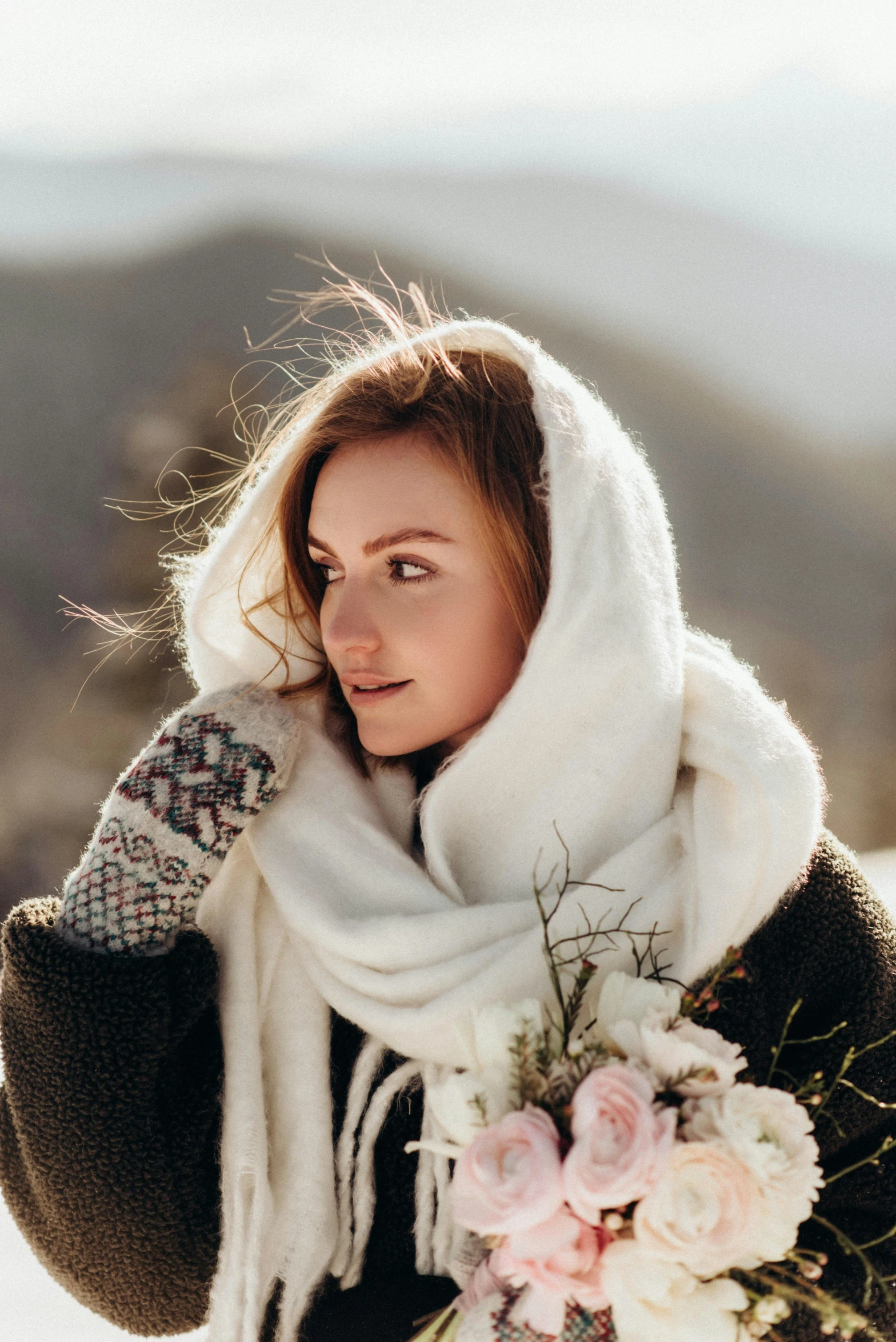 a girl wearing a scarf and holding a bouquet of flowers