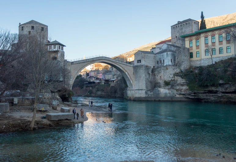 a stone arch bridge spanning the width of an old river