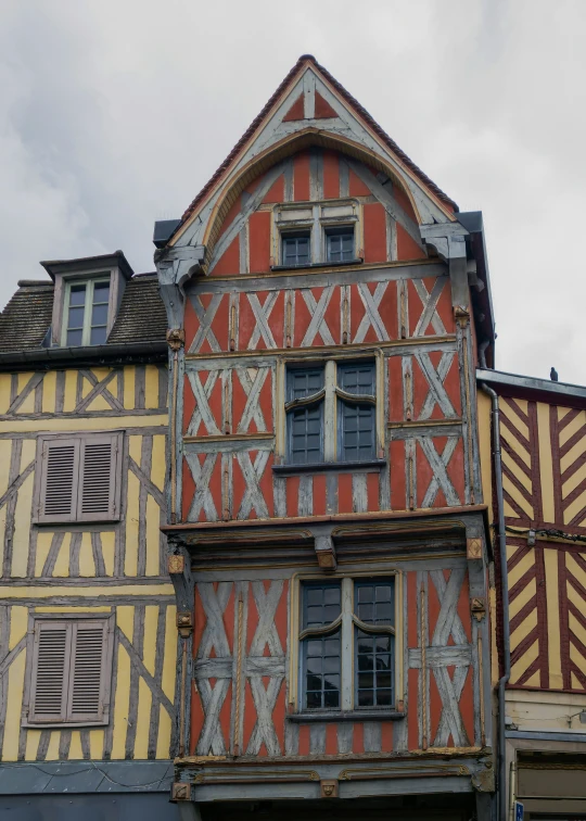 a building with colorful striped buildings with wooden shutters