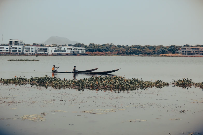 two men standing on a boat in a river