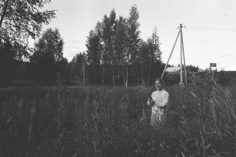 a woman in white dress standing in tall grass