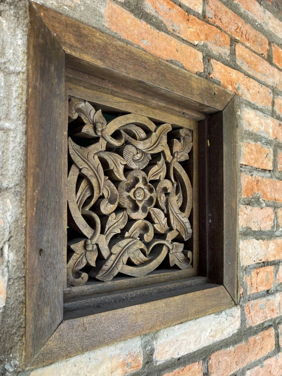 a square wood window with an intricate pattern in it