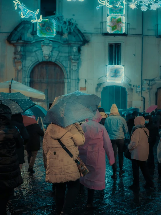 people standing in the rain with umbrellas near buildings