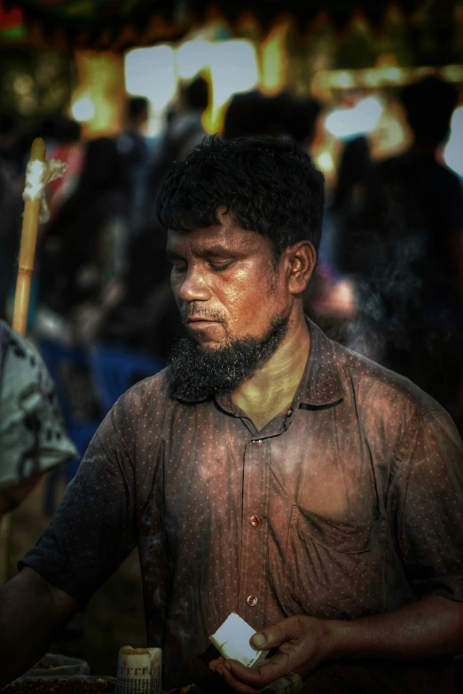 a man is smoking and standing in front of an outdoor market