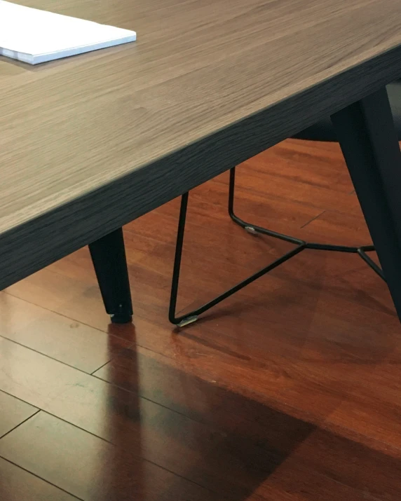 a laptop sits on a wooden table on hardwood