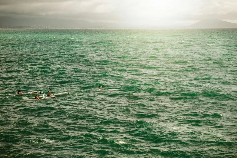 three people in canoes on large body of water