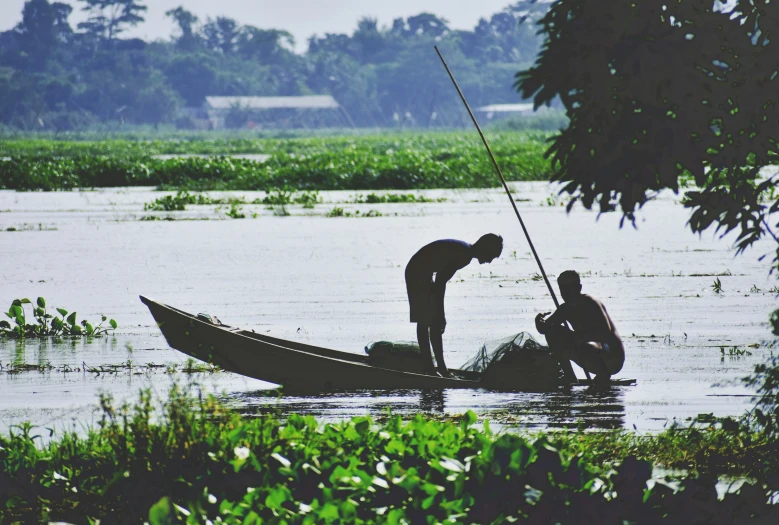 a group of men are fishing in the river