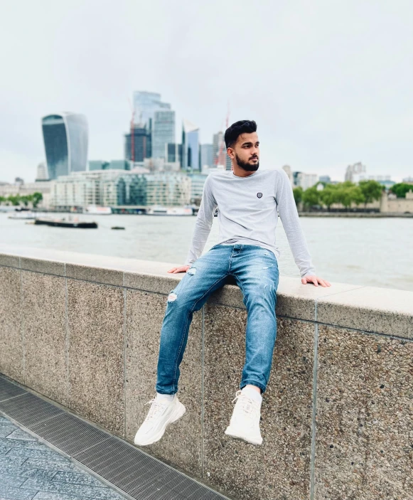 a man sits in a ledge outside by the river