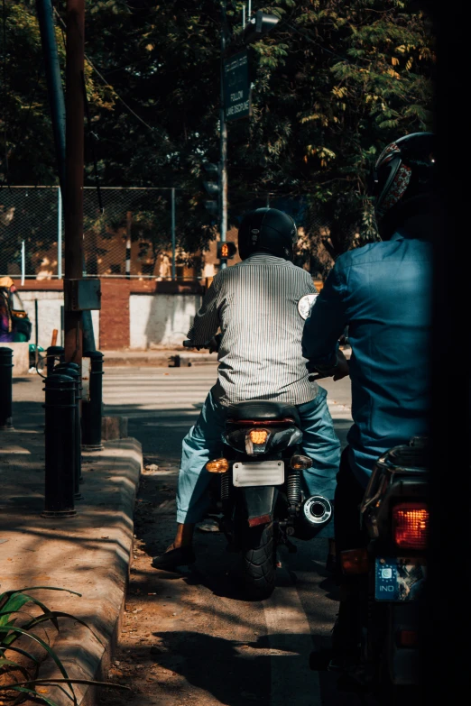 two people riding a motorcycle on a street