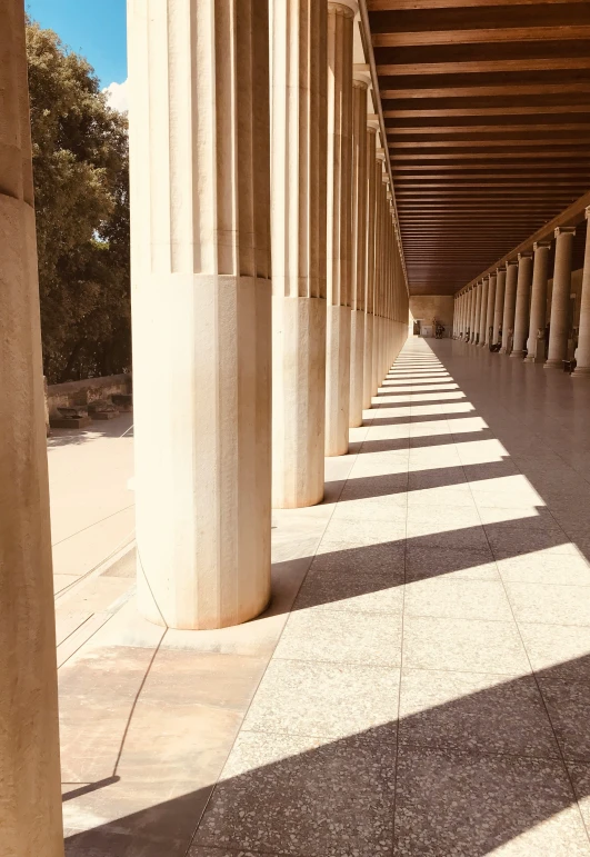 columns line the wall outside an empty room