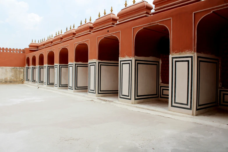 a courtyard area with benches and pillars in the sand