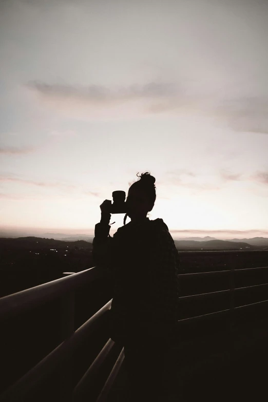 a person with a camera is looking over a railing