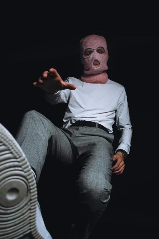 a man wearing a pink mask sitting down