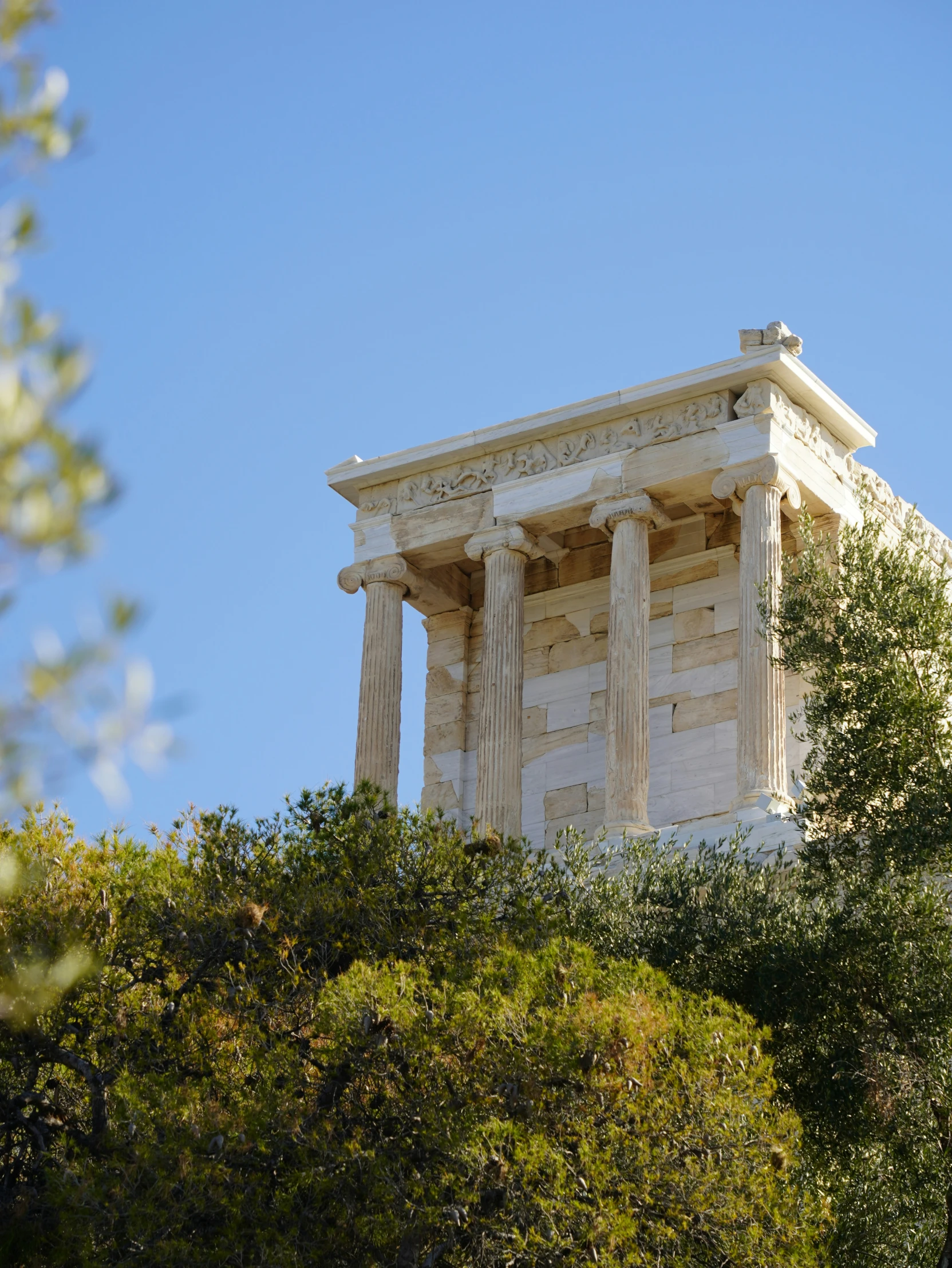 the top part of an old roman style building with columns