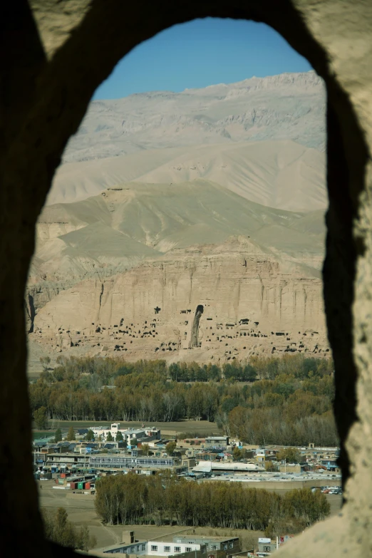 an old city below a large hill of mountains