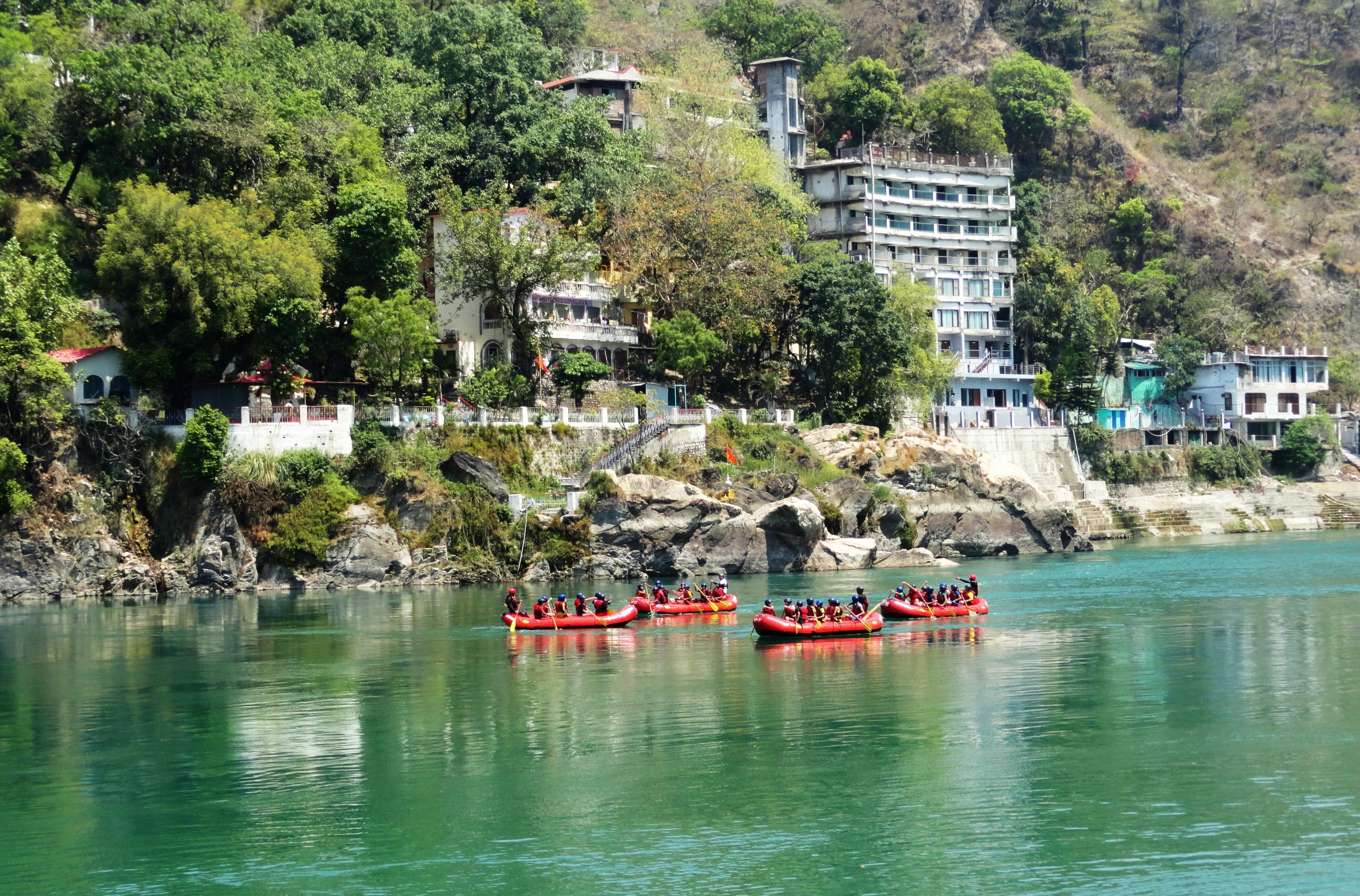 two boats filled with people riding on a river