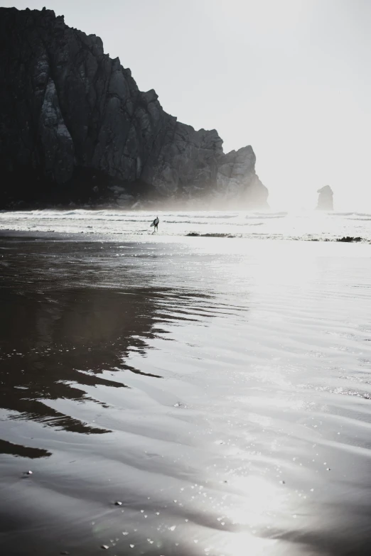 a person walking into the ocean from shore