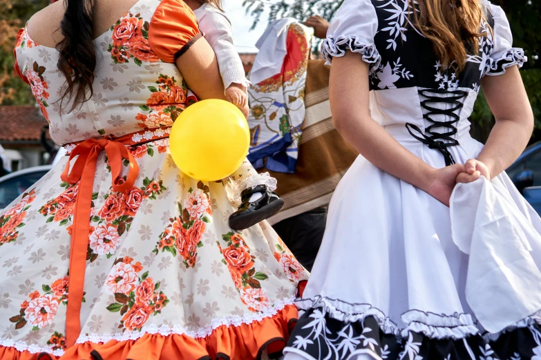 two women with large heads walking by an outdoor event