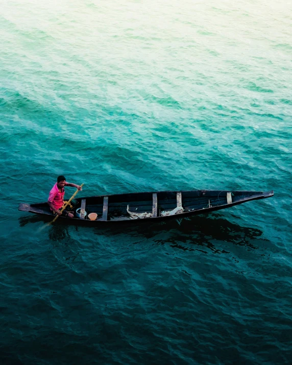 an aerial s of a man paddling a canoe