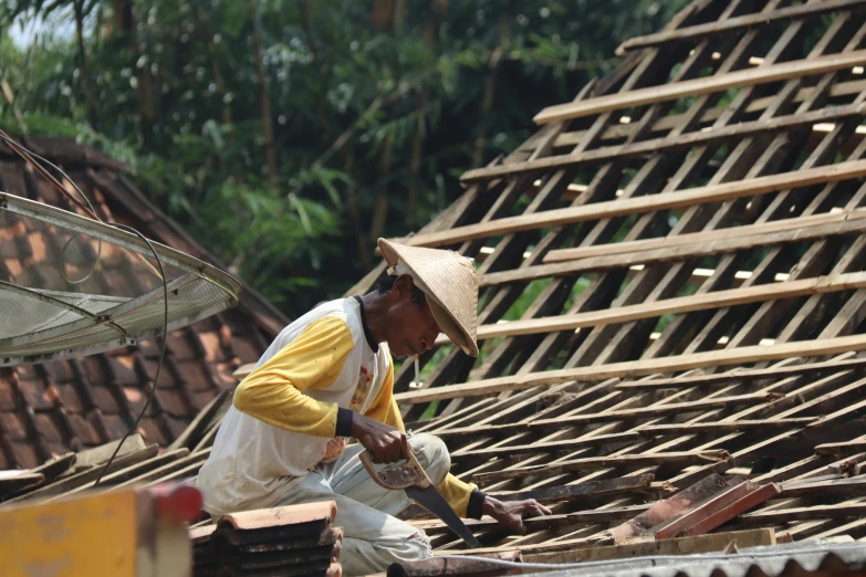 a man working with wooden shingles on top of a roof