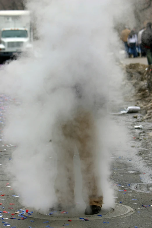 a man smoking soing on the street and covered in steam