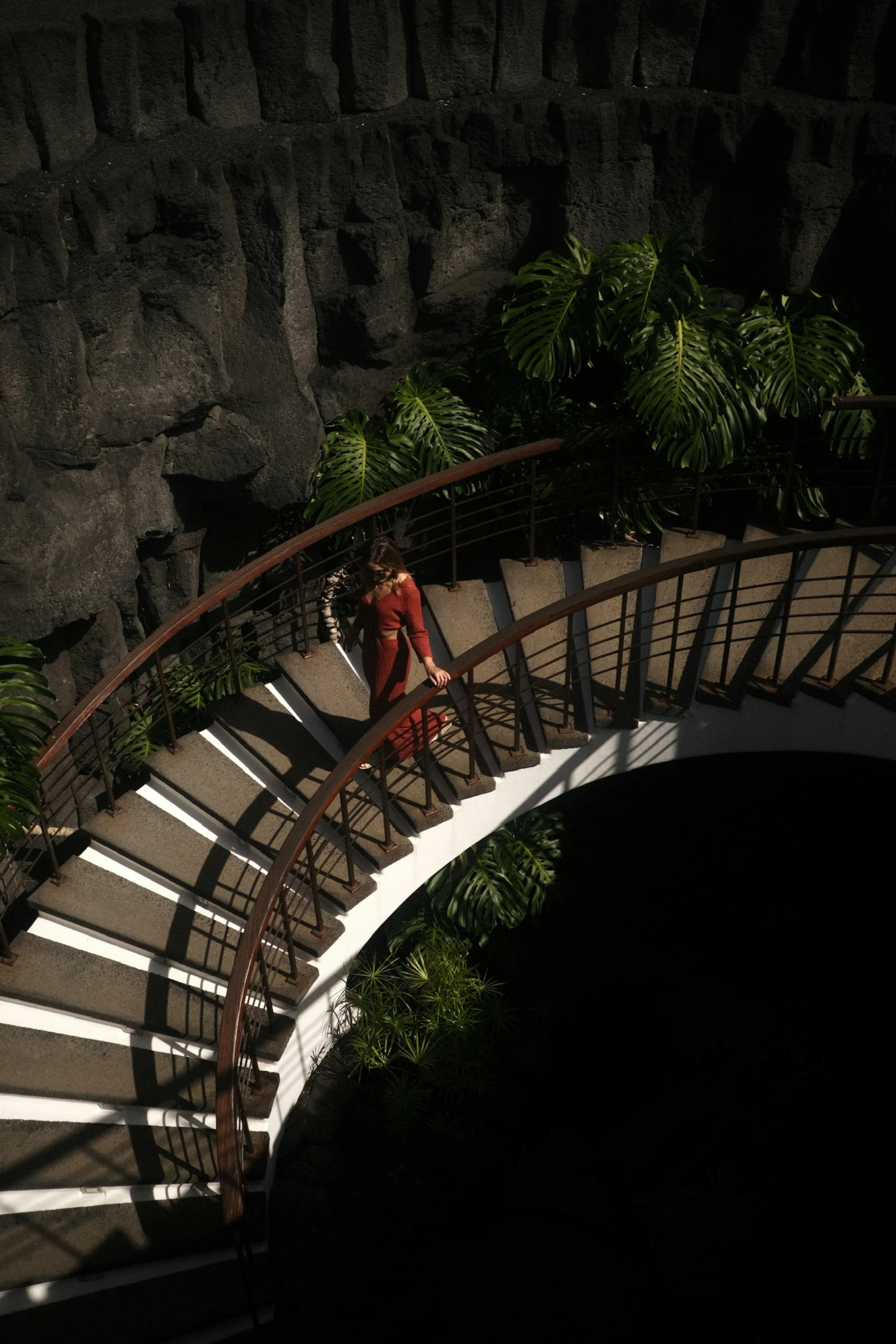 a woman walking up the side of a metal staircase