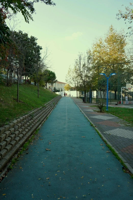 an empty street on a hill with a blue sidewalk