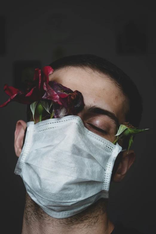 a man wearing a white face mask with flowers in it