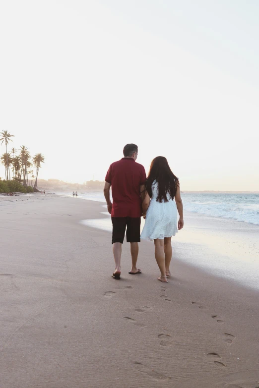 the man and woman are standing together at the beach