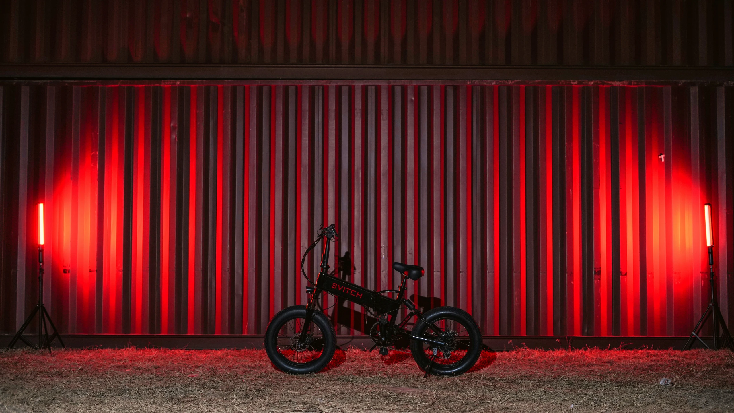 a motor bike stands against a red wall